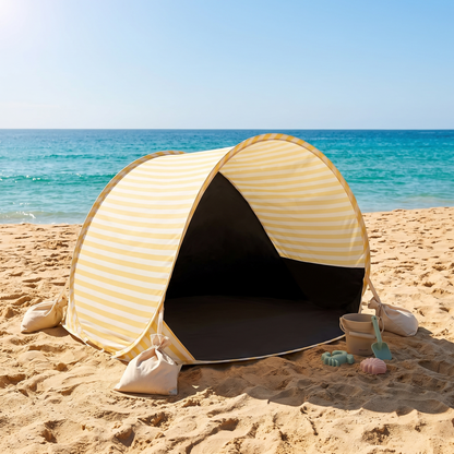 Kids pop-up beach tent anchored with sandbags on a sunny Australian beach with sand toys