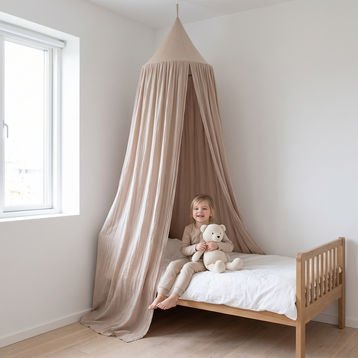 Child sitting on a bed beneath the nougat bed canopy
