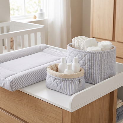 Quilted storage baskets stocked with nappies and essentials on a change table
