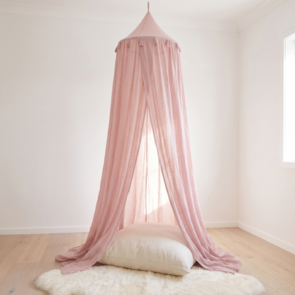 Dusty pink sheer hanging bed canopy in a bright kids bedroom