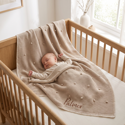 Close-up of bobble knit texture and embroidered name on natural cotton baby blanket