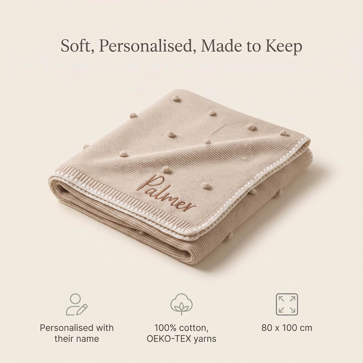 Baby lying on a personalised cream knitted bobble blanket