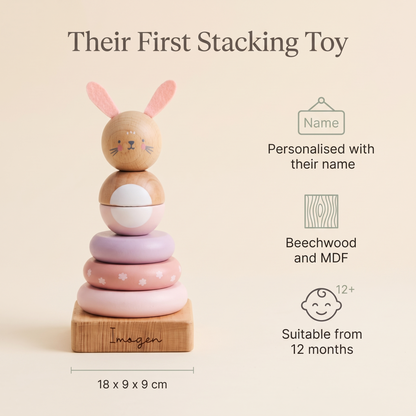 Baby playing with a personalised pink wooden bunny stacker