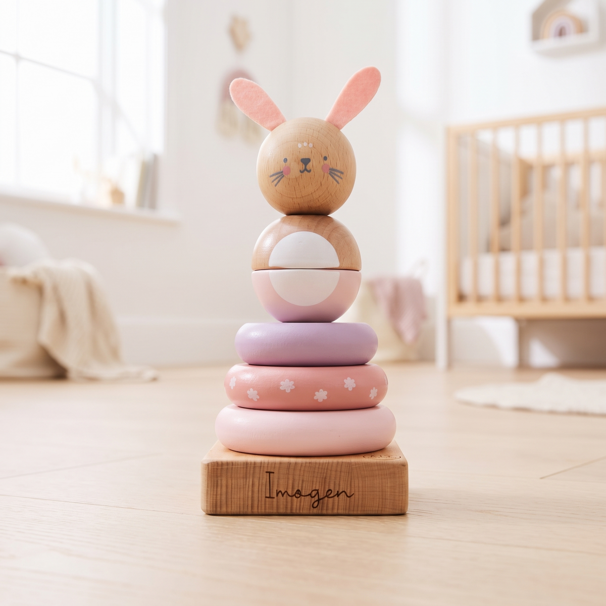 Personalised pink wooden bunny stacker toy with engraved name on a nursery shelf
