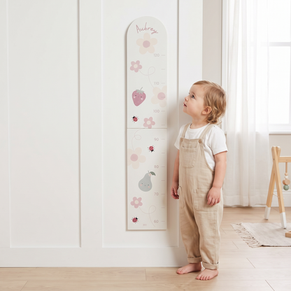 Close-up of bloom and blossom illustrations and child's name on wooden height chart