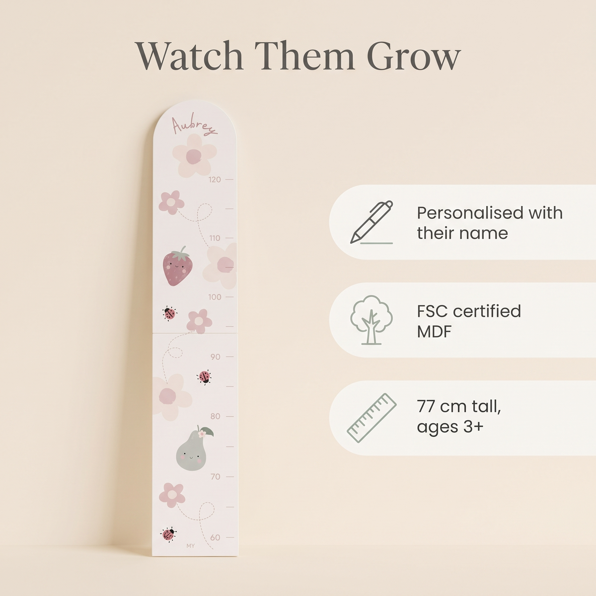 Child being measured against a personalised bloom and blossom wooden growth chart