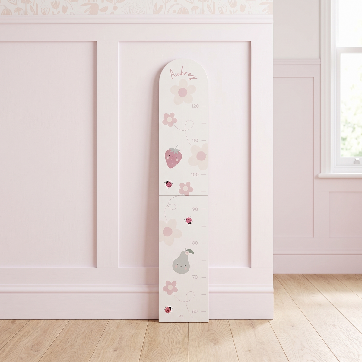 Personalised pastel floral wooden height chart with printed name on a nursery wall