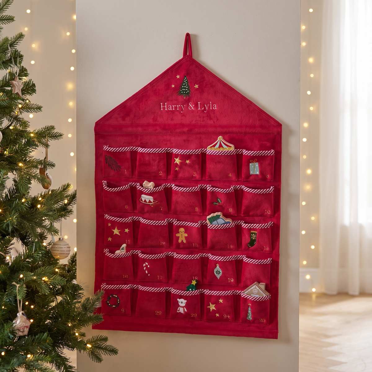 Personalised red velvet hanging advent calendar with 24 candy-cane trimmed pockets