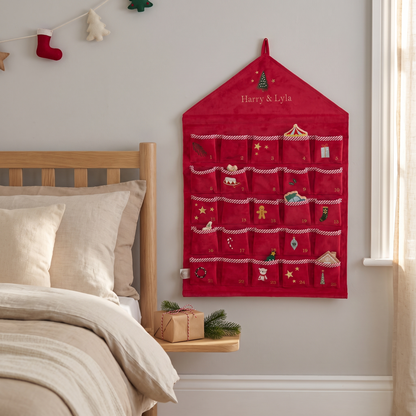 Close-up of embroidered name and Christmas tree motif on red velvet advent calendar