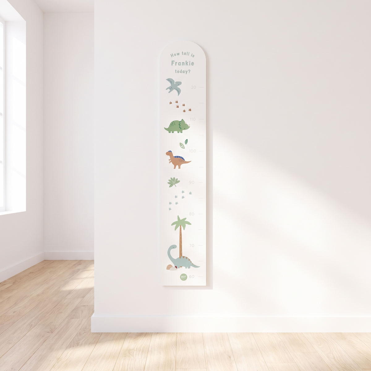 Personalised pastel dinosaur wooden height chart with printed name on a nursery wall
