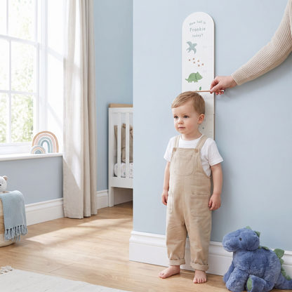 Close-up of dinosaur height chart showing rainbow accents and printed name