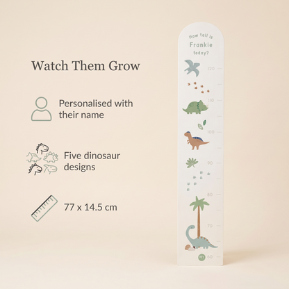 Child being measured against a personalised dinosaur wooden height chart