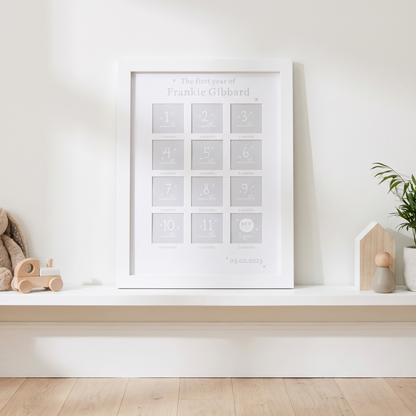Personalised first year baby photo frame with name and date of birth on a nursery wall