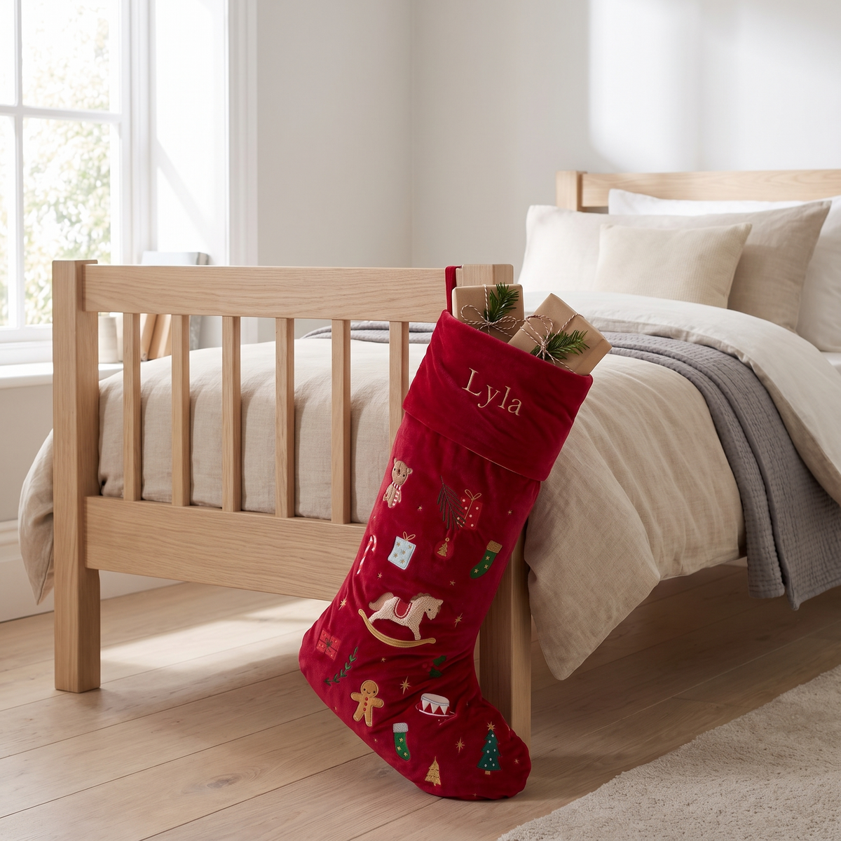 Close-up of embroidered name and Christmas motifs on red velvet stocking cuff