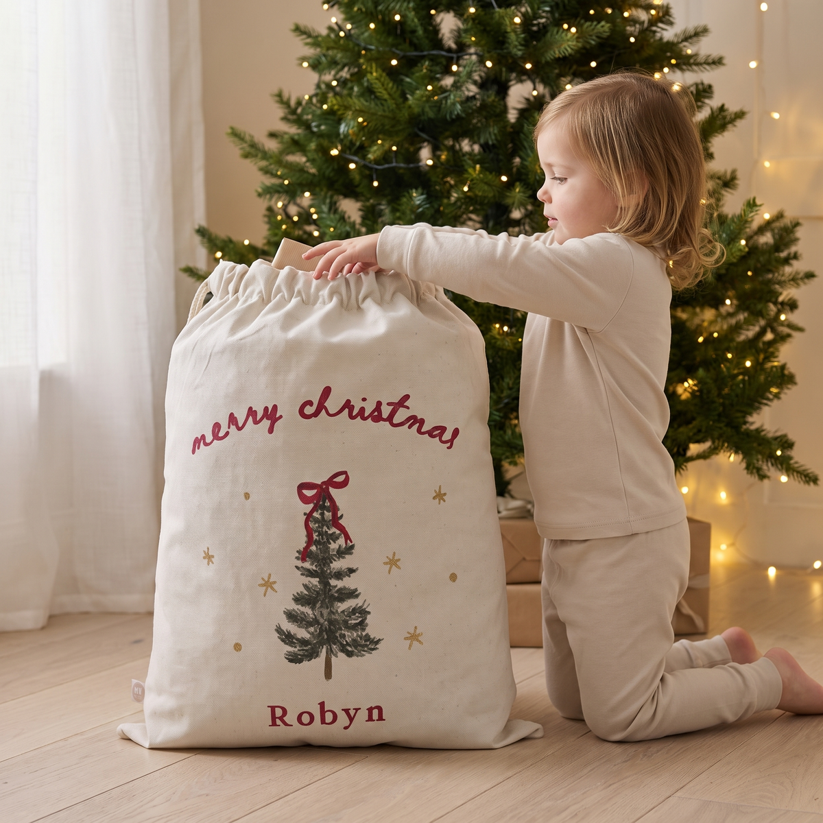 Cream Christmas tree Santa sack beside a decorated tree in a family living room