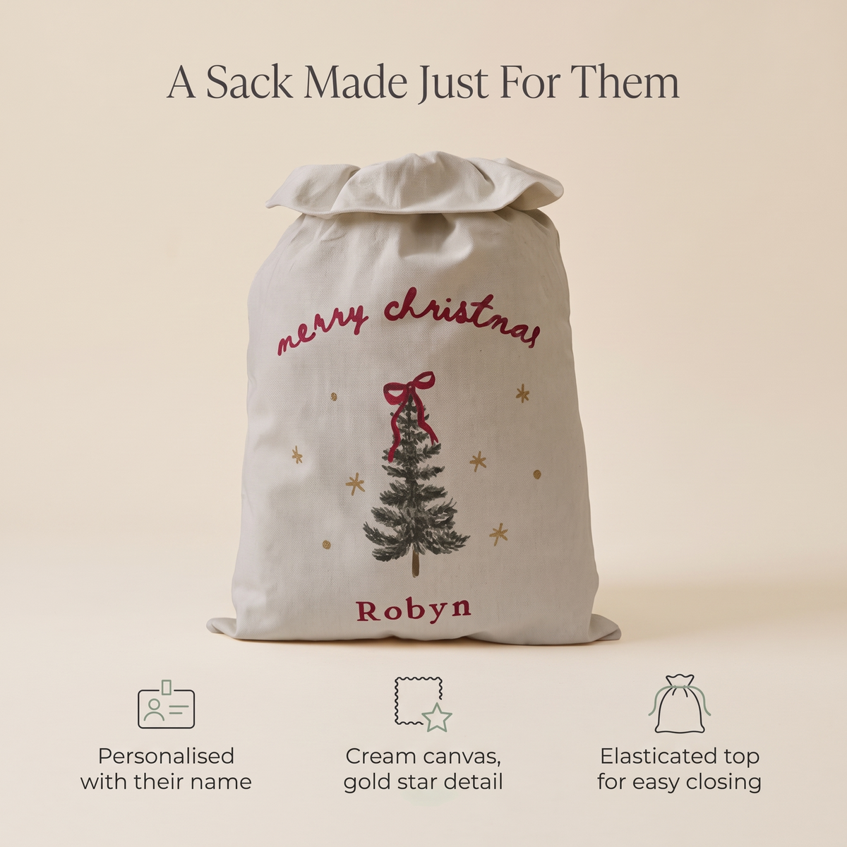 Child with a personalised cream canvas Santa sack on Christmas morning