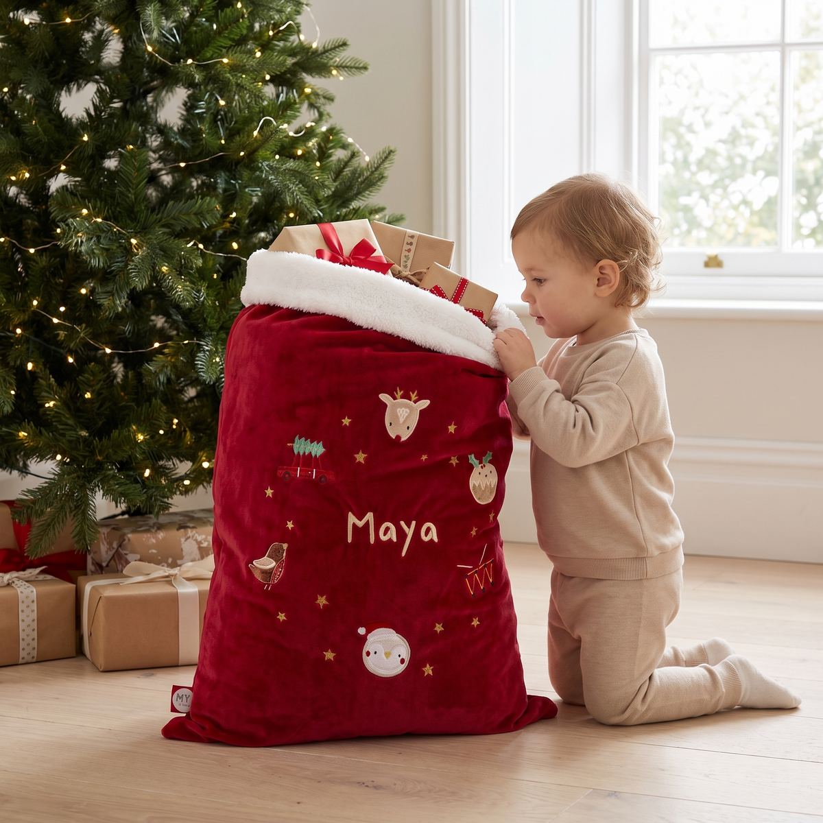 Red embroidered Santa sack under a Christmas tree in a family living room