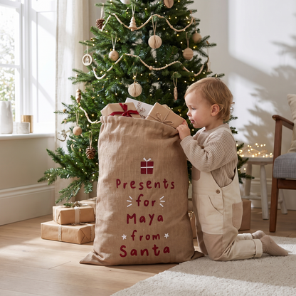 Hessian personalised Christmas sack beside a decorated tree