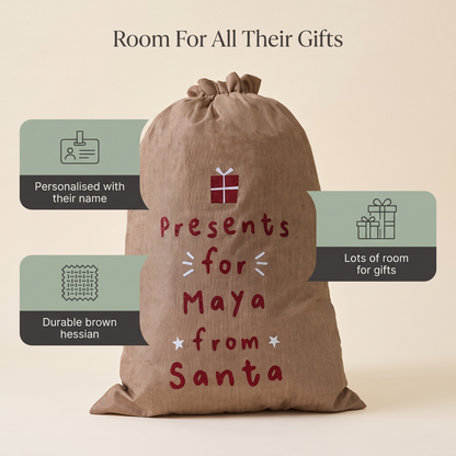 Child with a personalised hessian Santa sack on Christmas morning