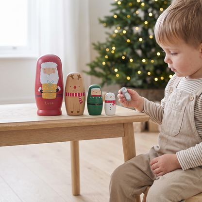 Christmas nesting dolls lined up on a shelf with festive decorations