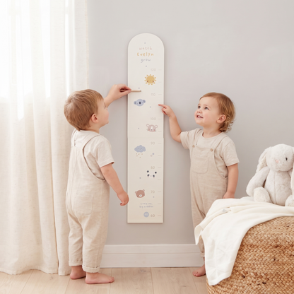 Close-up of mini mono animal illustrations and child's name on wooden height chart