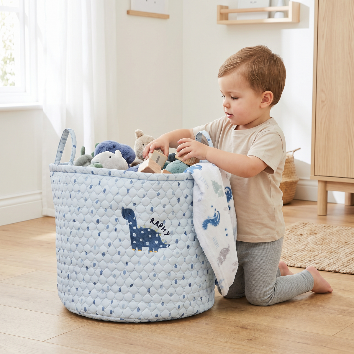 Close-up of embroidered name on blue dinosaur quilted toy storage bag