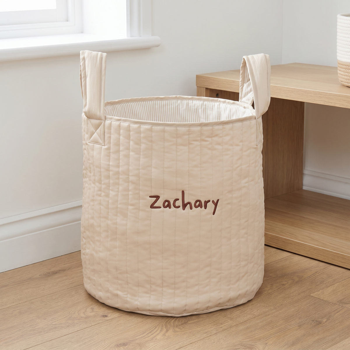 Personalised neutral storage bag with ticking stripe lining in a nursery