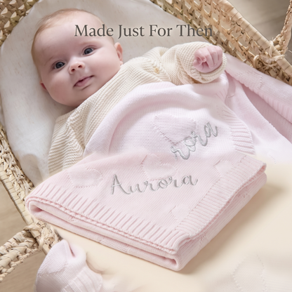 Baby lying on a personalised pale pink heart jacquard cotton blanket