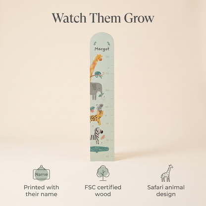 Child being measured against a personalised safari wooden growth chart