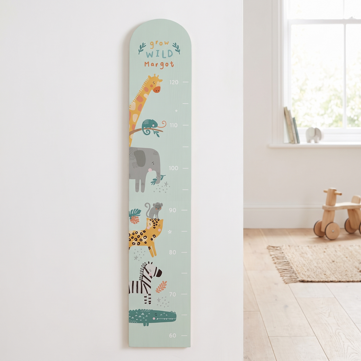 Personalised pastel green safari wooden height chart with printed name on a nursery wall