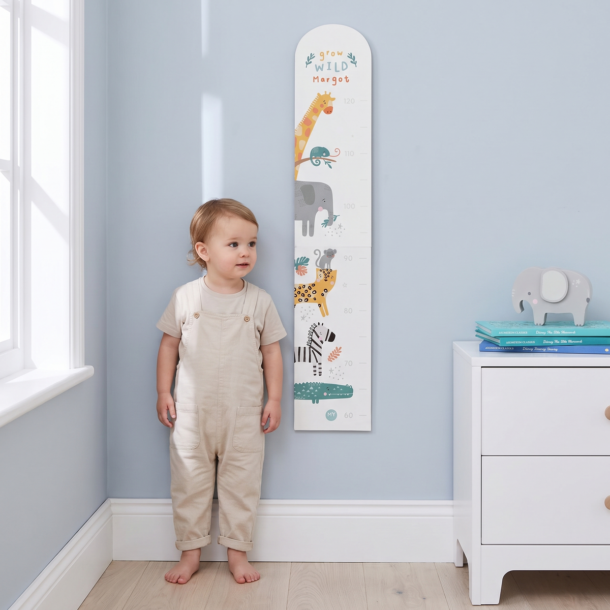 Close-up of safari animal illustrations and child's name on wooden height chart