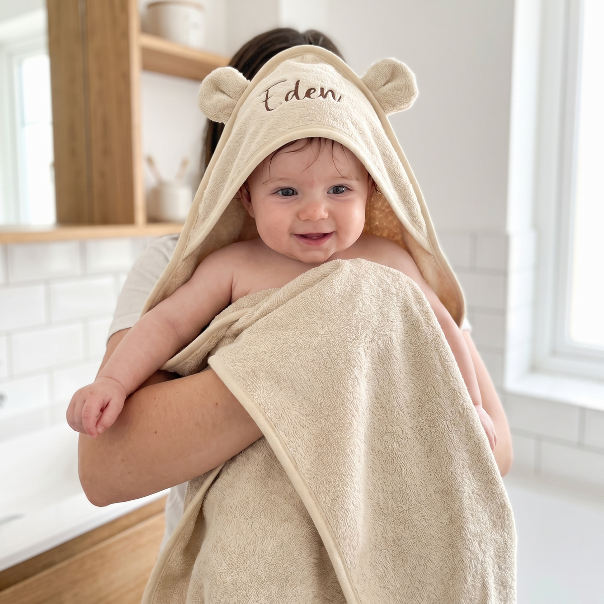 Close-up of embroidered name on hood of natural beige baby towel