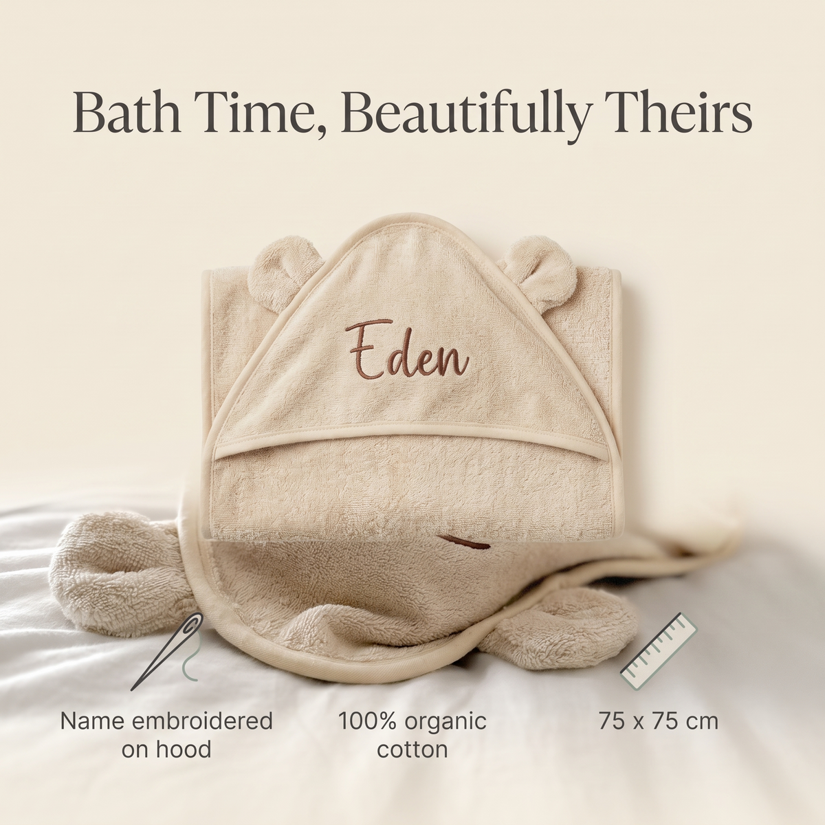 Baby wrapped in a personalised natural beige hooded towel after bath time