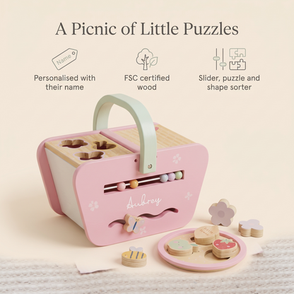 Toddler playing with a personalised pink wooden picnic shape sorter