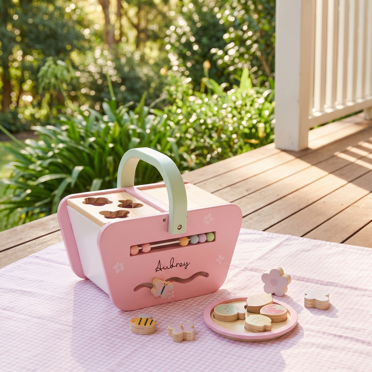 Pink picnic shape sorter with wooden shapes laid out on a playmat
