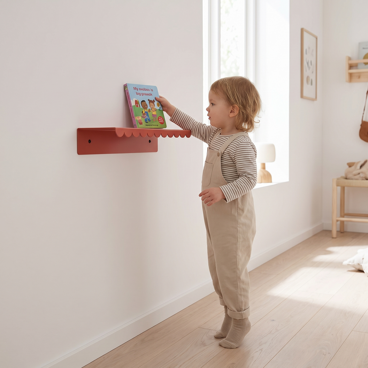 Red steel wall shelf displaying picture books in a playroom