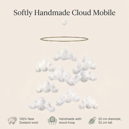 Cloud mobile styled above a nursery with soft white decor