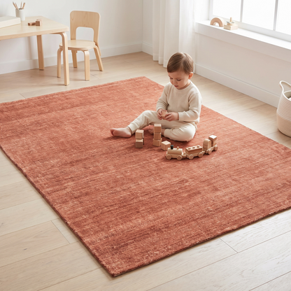 Terracotta distressed washable rug styled in a nursery under a cot