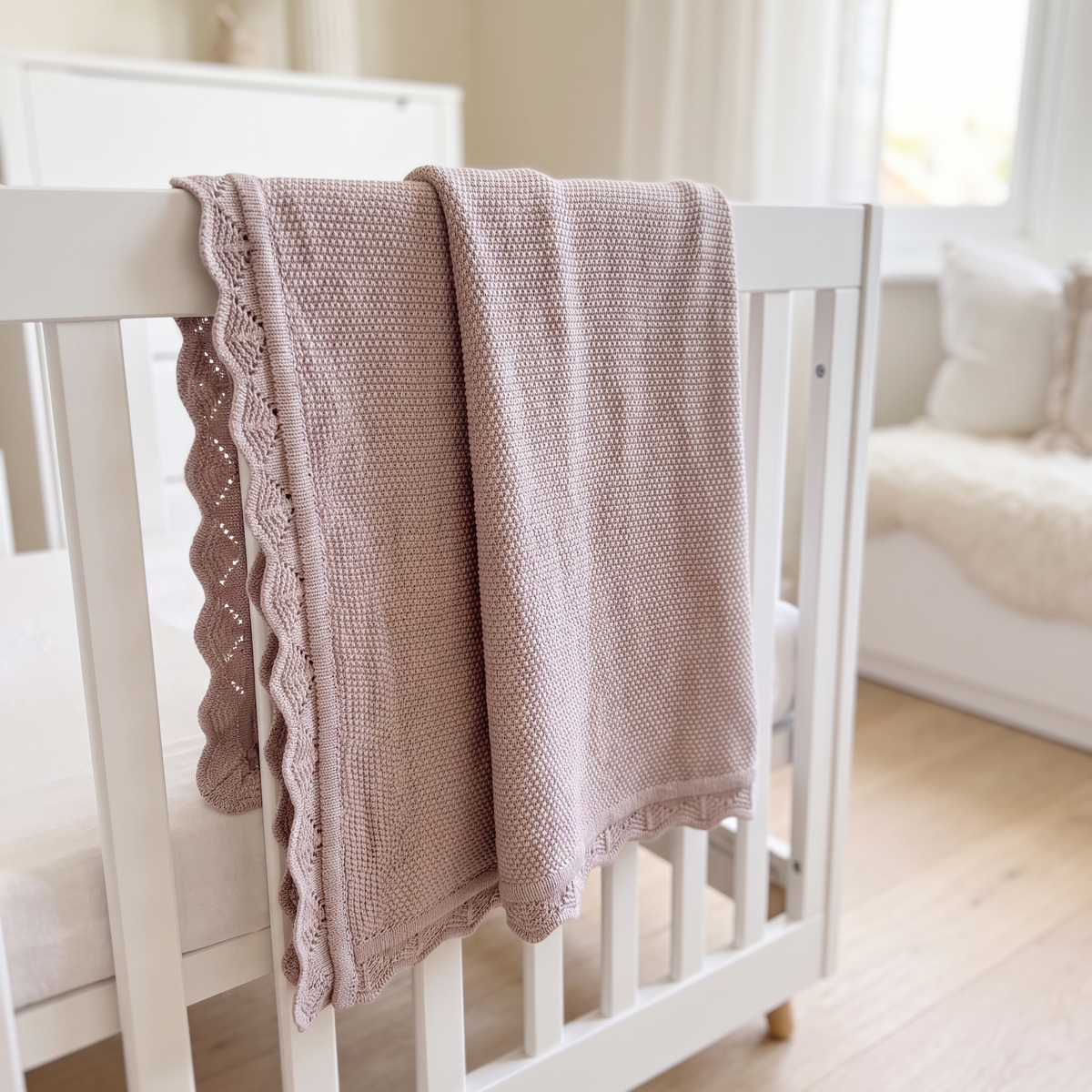 Little Teekie dusty lilac knitted cotton baby blanket folded in a nursery