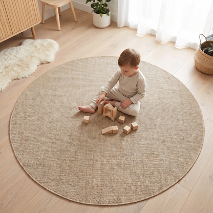 Beige round flatweave rug styled in a nursery reading corner