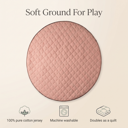 Round dusty pink quilted play mat styled in a soft neutral nursery
