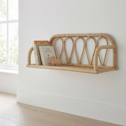 Small natural rattan wall shelf mounted in a nursery with books and toys