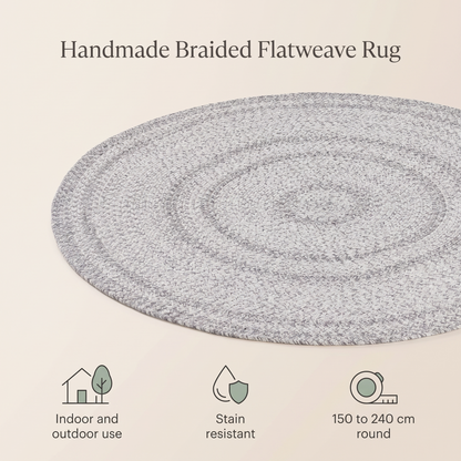 Grey braided round rug in a bright kids bedroom with toys
