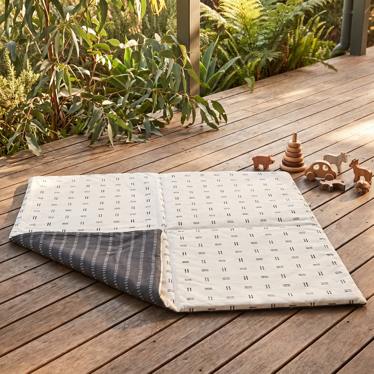 Mudcloth padded play mat set up for tummy time in a bright playroom
