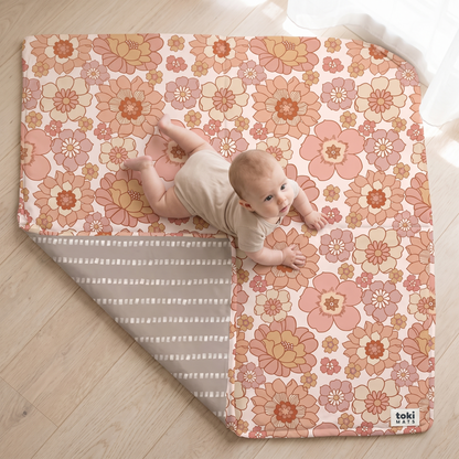 Close-up of the blooms floral organic cotton fabric and padding on the play mat