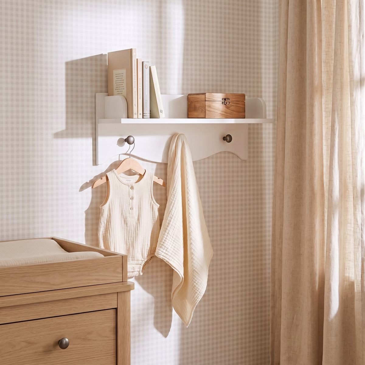 Close-up of white wall shelf pegs holding a small bag and hat