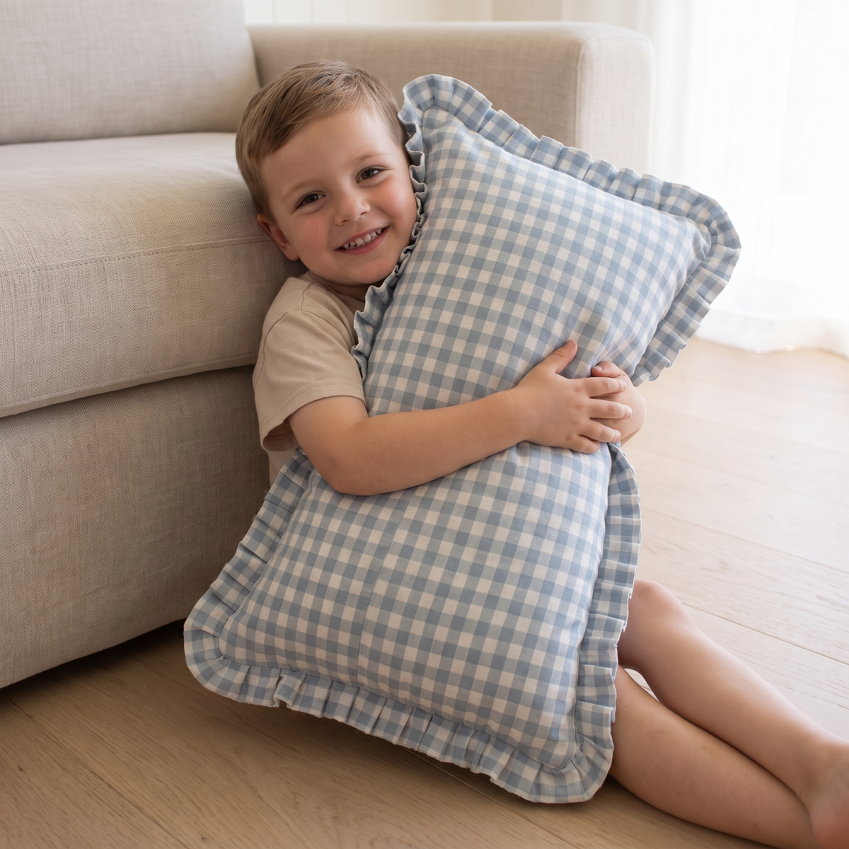 Little Teekie Personalised Gingham Ruffle Cushion Cover | Embroidered Name, 55 x 35cm – Blue – in use, shows scale